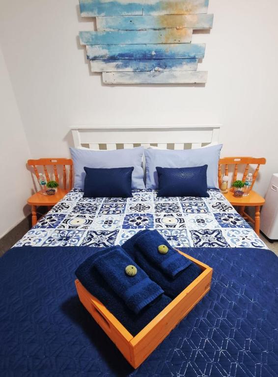 a bed with blue sheets and blue pillows on it at Agulhas Stay in Agulhas