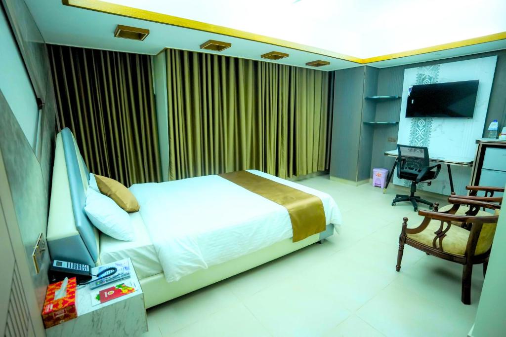a bedroom with a bed and a desk and a chair at City Inn Ltd in Khulna