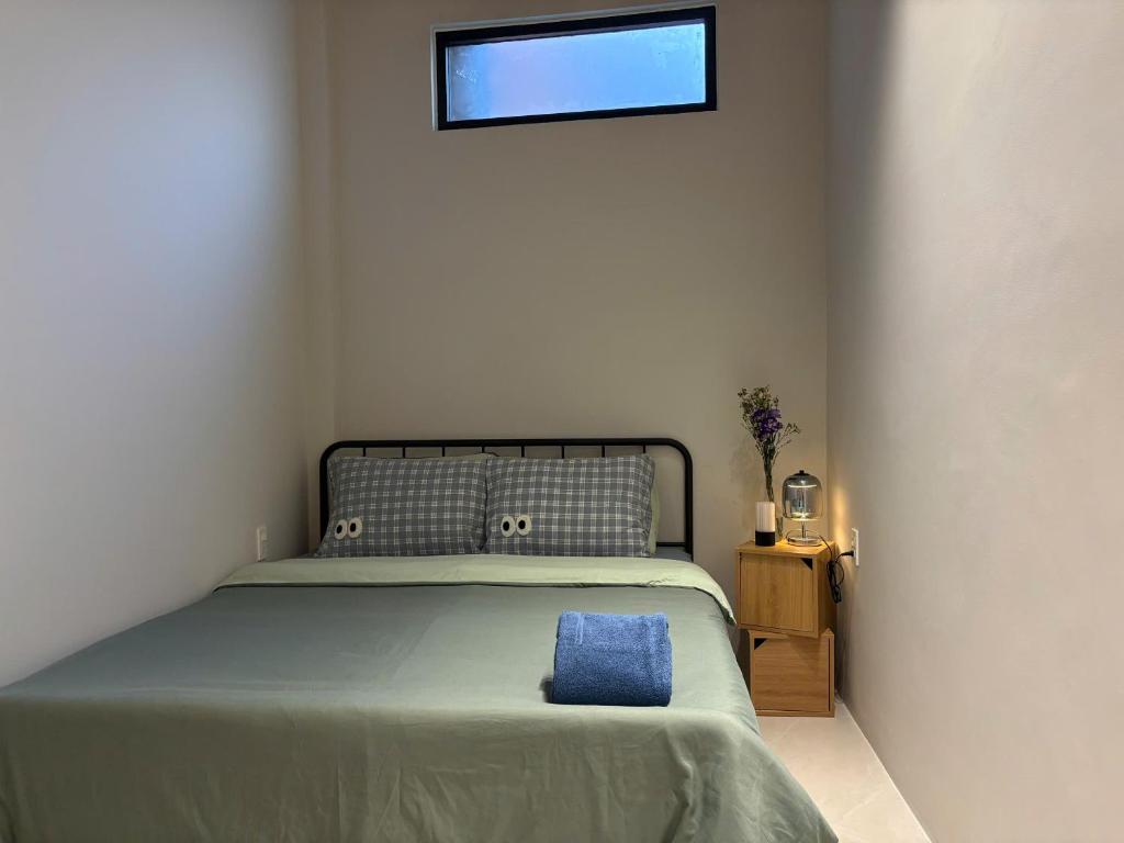 a bedroom with a bed with a blue pillow on it at Êm Êm Homestay Đảo Lý Sơn in Ly Son
