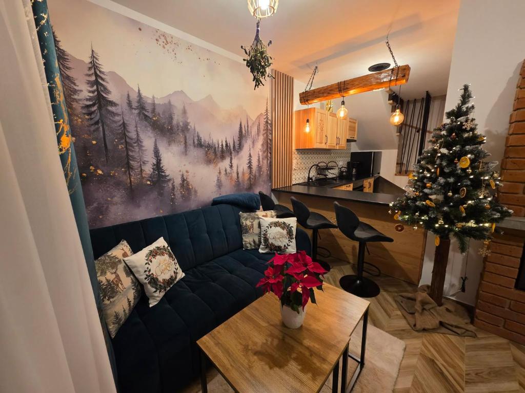 a living room with a blue couch and a christmas tree at Family House B in Witów