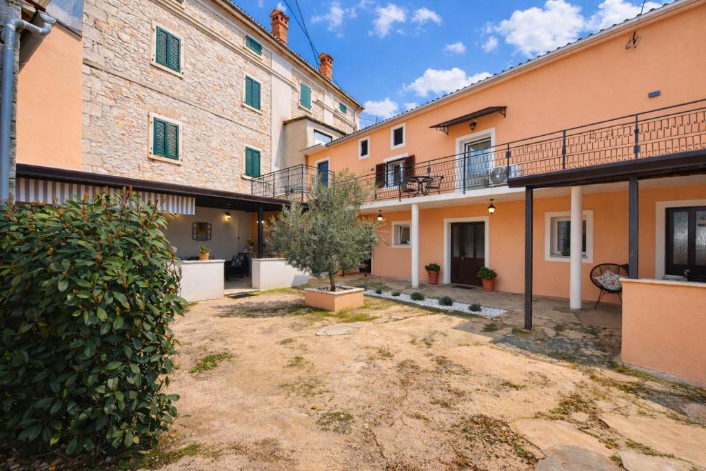 a courtyard of a building with a tree in a yard at House Kanižela 2418 in Nova Vas