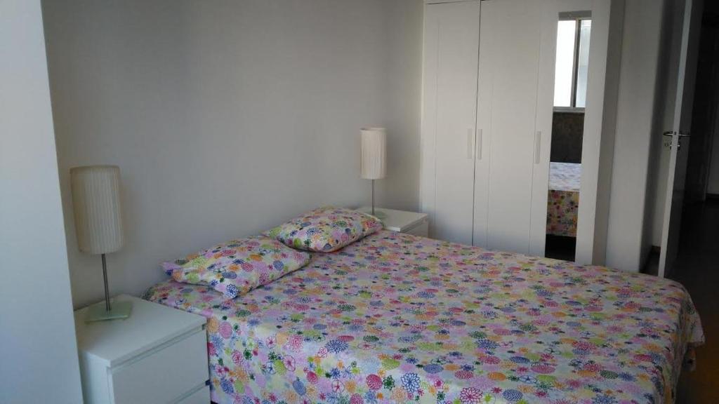 a bedroom with a bed and two lamps and a window at Apartamento Avenida 5 de Outubro in Lisbon