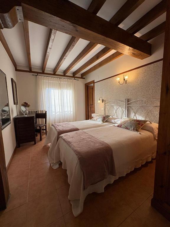 a bedroom with a large bed and a table at Eco de las Cuevas in Santillana del Mar