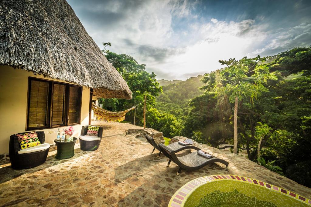 a house with chairs and a view of the mountains at ONE Santuario Hotel y Reserva Natural in Palomino