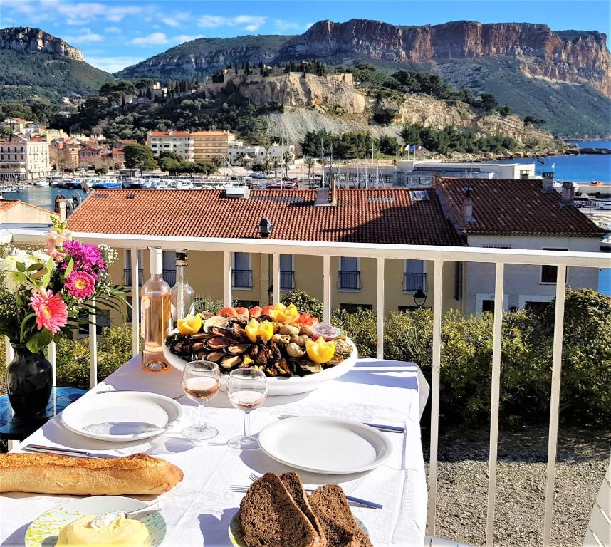 a table with bread and wine glasses on a balcony at Le Bellavista T2 Cassis Emplacement in Cassis