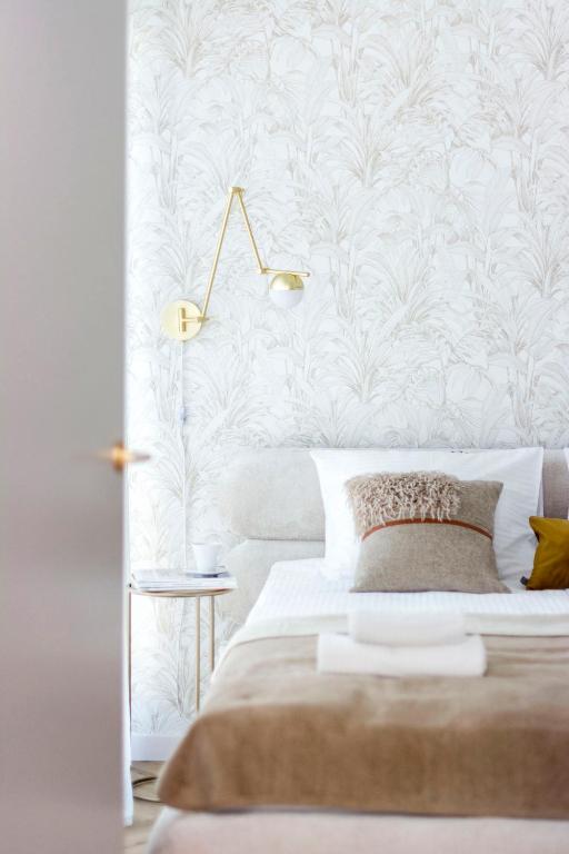 a bedroom with a bed with a white wall at Sol Marina - Marina 165 in Wiślinka