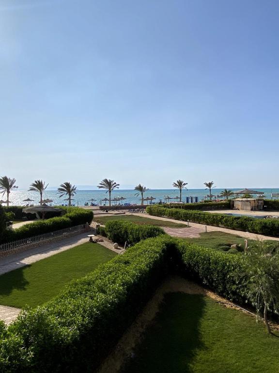 a view of a park with palm trees and the ocean at Golden Beach 2 Resort in Ras Sedr