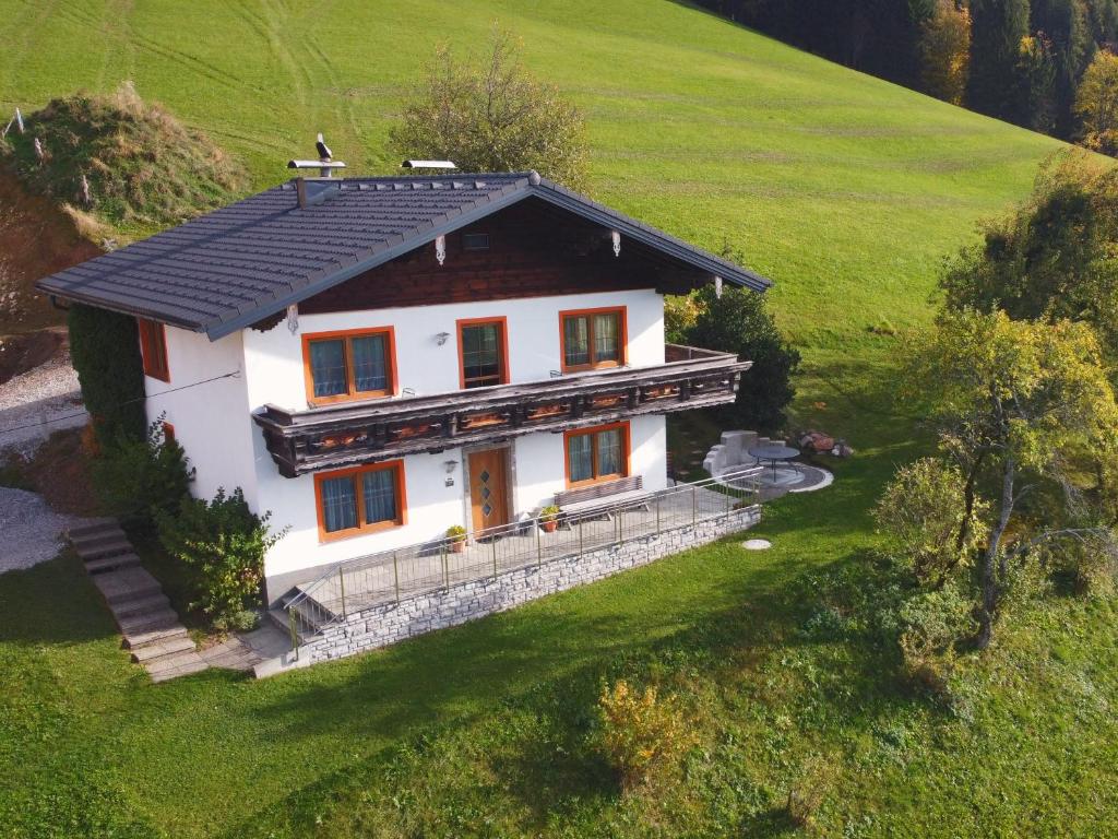 a white house with a black roof on a green field at Ferienhaus Englbrecht in Krispl