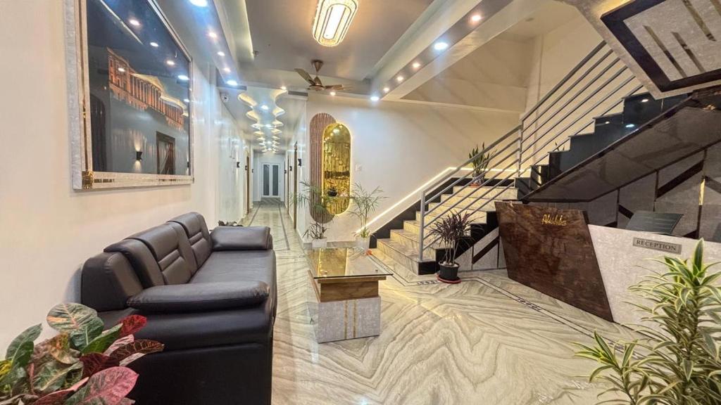 a living room with a couch and a staircase at Alishba Hotel And Restaurant in Lālbāgh