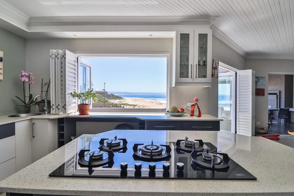 a kitchen with a view of the ocean from theinsula at Central, Beachfront Home in Jeffreys Bay