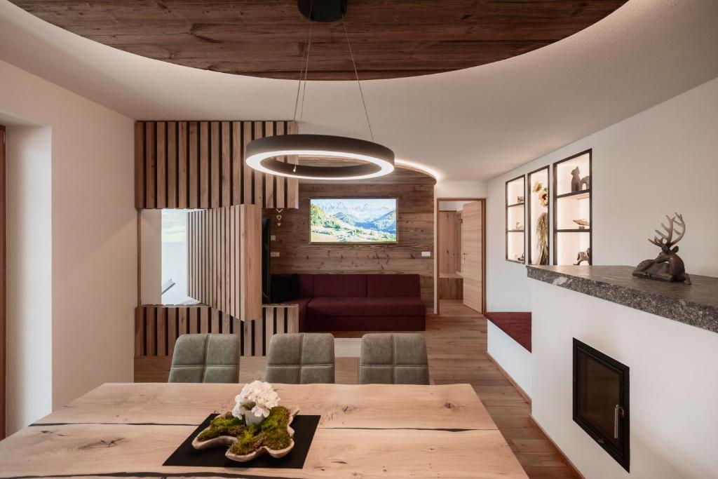 a dining room and living room with a table and chairs at Deluxe Apartments Lantl in Falzes