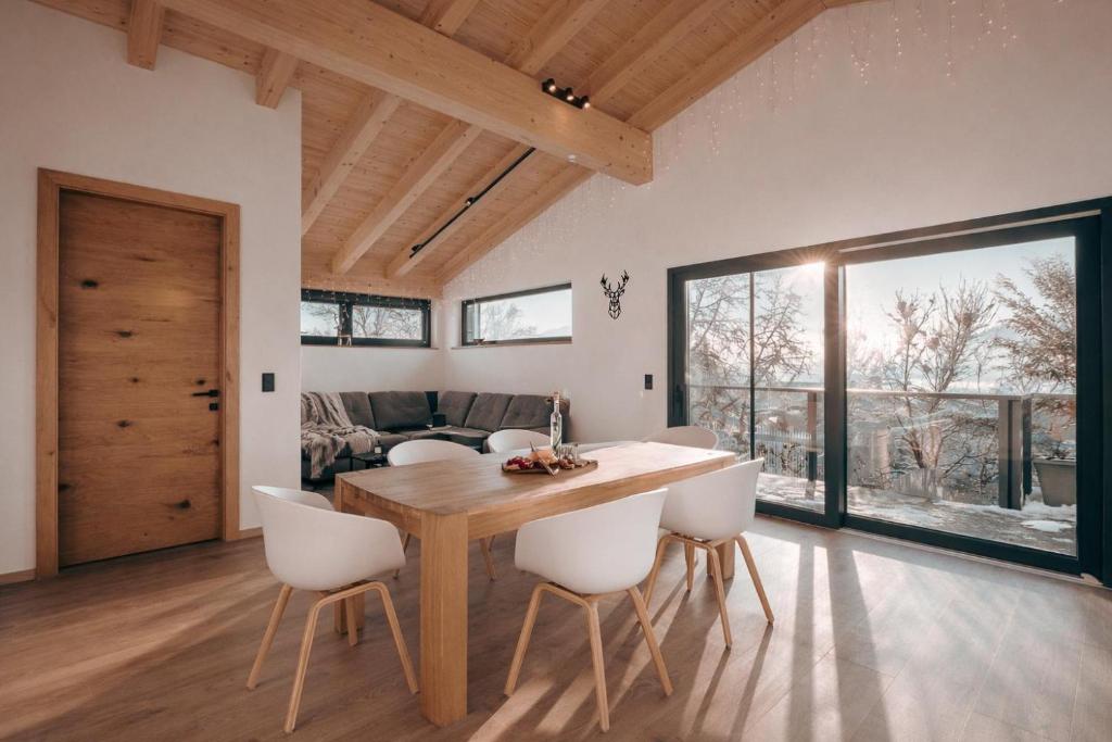 a dining room with a wooden table and white chairs at Mountain Residence in Going am Wilden Kaiser
