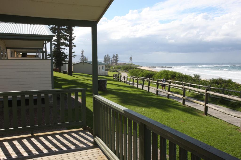 eine Veranda mit Blick auf den Strand in der Unterkunft Bulli Beach Tourist Park in Bulli