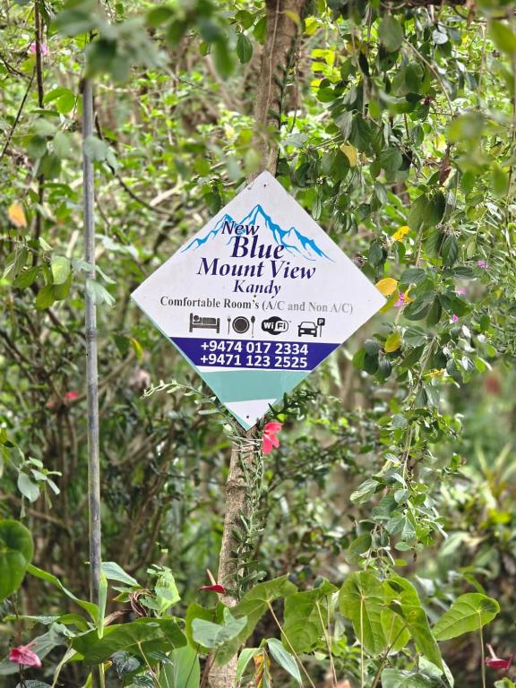 a sign hanging from a tree in a forest at Hotel Blue Mount View Kandy in Kandy