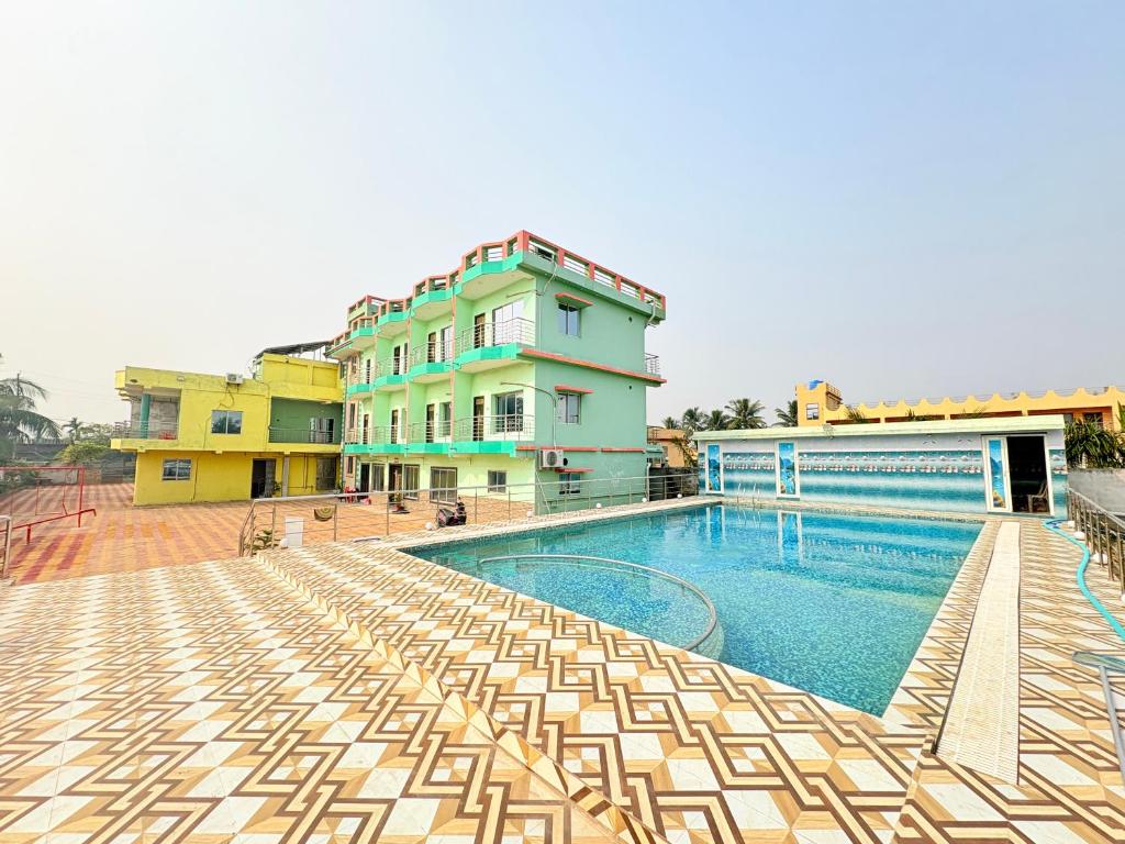 a swimming pool with chairs in front of a building at Manas Kanya Mandarmani Hotel & Restaurant - Swimming Pool - Banquet - Parking Facility Full AC Room in Mandarmoni