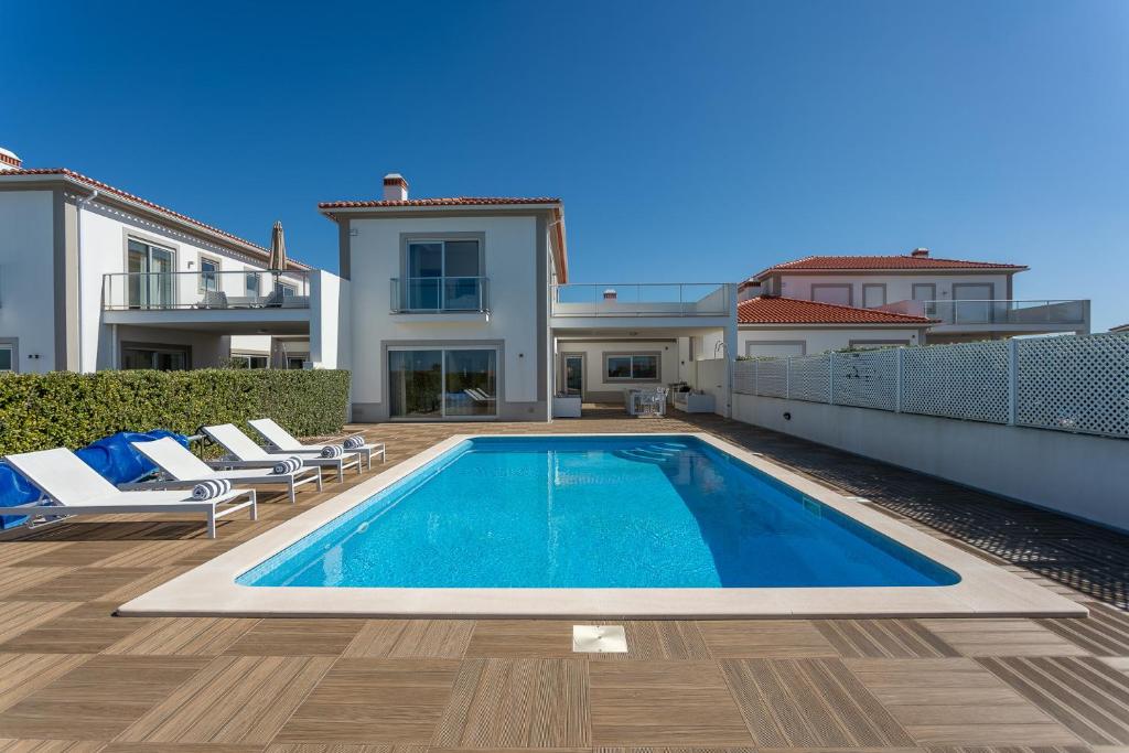 a swimming pool in the backyard of a house at Villa del Rey VIII in Casal da Lagoa Seca