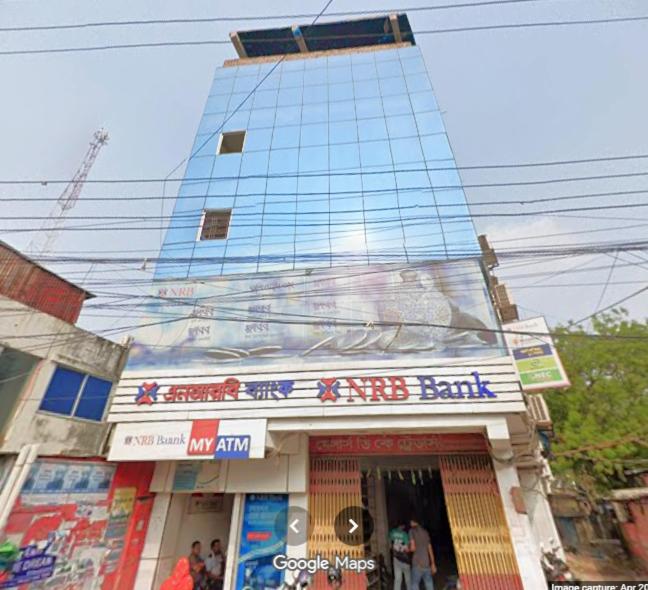 a tall building with a sign in front of a store at MD HoTEL in Iswardi