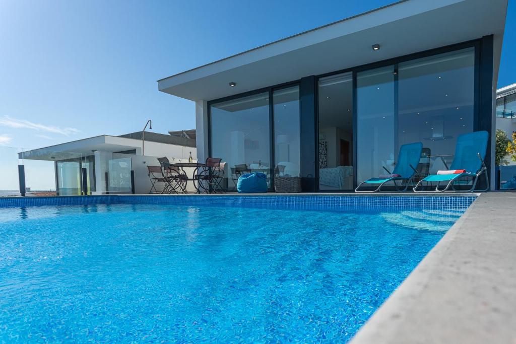 a swimming pool in front of a house at Villa Sao Martinho in São Martinho do Porto
