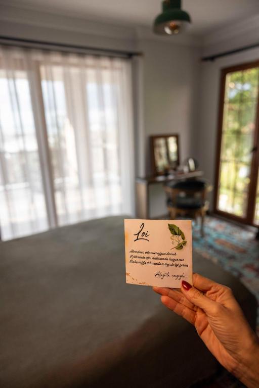 a person holding a piece of paper in their hand at Loidevilla in Çamurlu