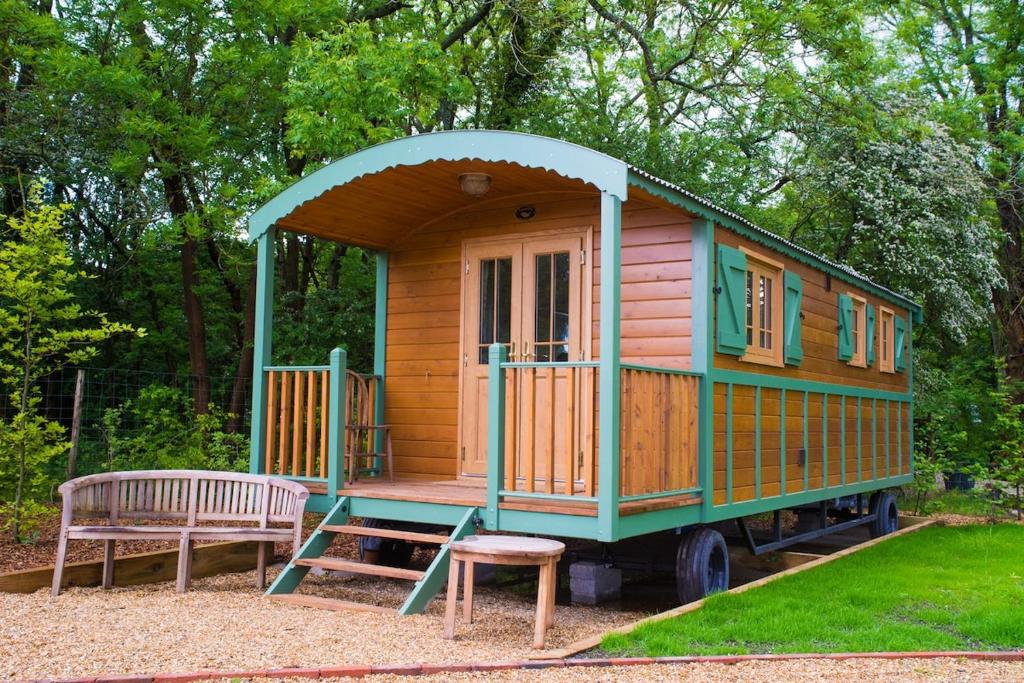 a small house on a truck with a bench at Le Grande Roulotte in Hassocks