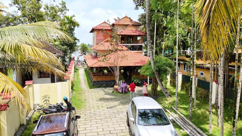 a house with a car parked in front of it at Atharvam Resort in Cherai Beach