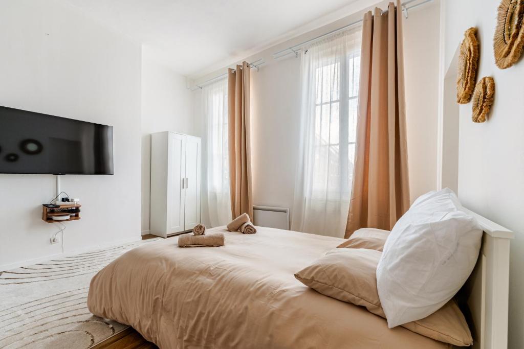 a bedroom with a large bed with a flat screen tv at Charmant Studio Cosy - Hyper-Centre D'Elbeuf in Elbeuf