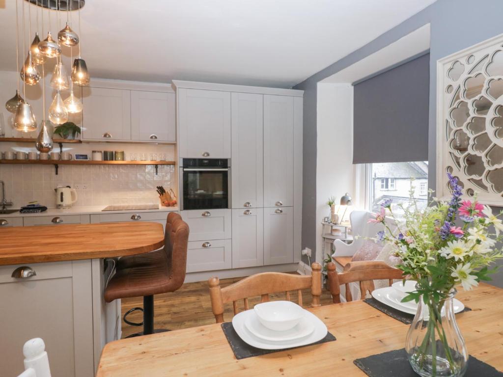 a kitchen and dining room with white cabinets and a table at The Wonky Nest in Windermere