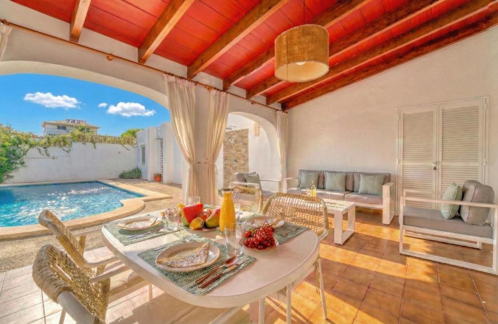 a dining room with a table and a pool at Ideal Property Mallorca - Christin in Cala Ratjada