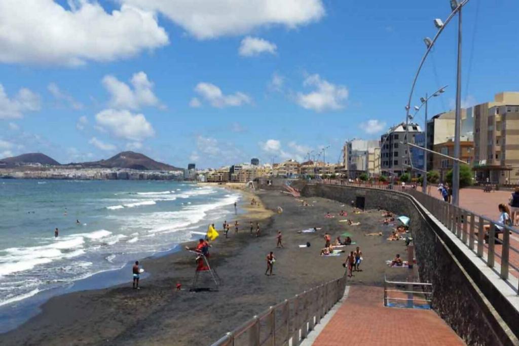 a beach with people on the sand and the ocean at Guanarteme Vista Surf, Las Canteras in Las Palmas de Gran Canaria