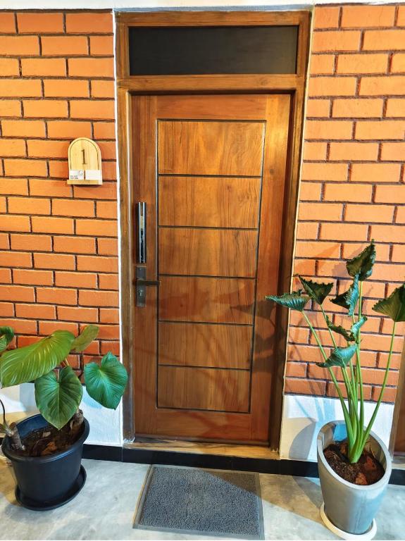 a wooden door with two potted plants in front of it at bluemoonhiriketiya in Dickwella