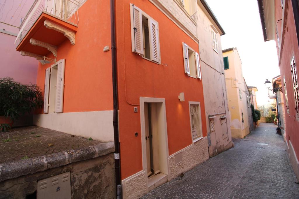 an alley with an orange building on a street at Dimora Centro Storico in Sirolo