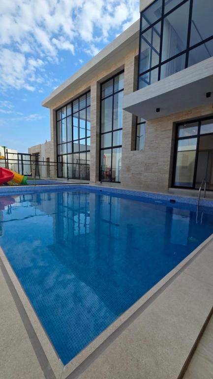 a large swimming pool in front of a building at Al Mona Resort 2 شاليه المنى in Al Khobar