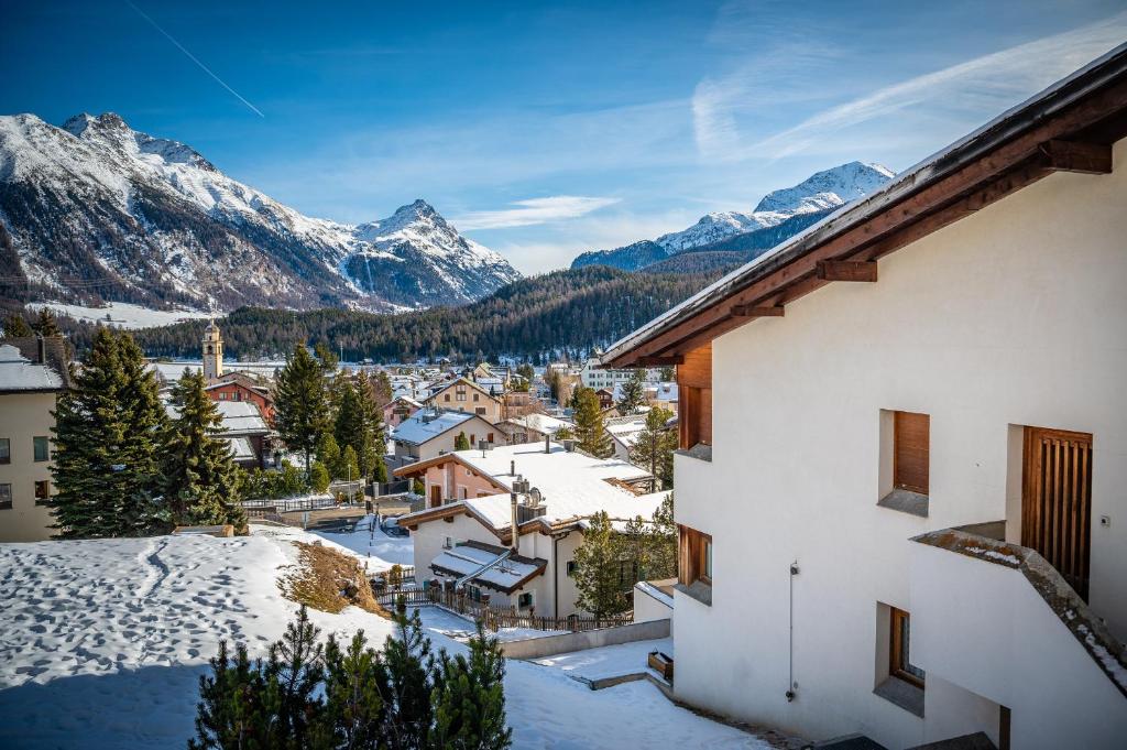 a view of a town with snow covered mountains at Chesa Sarvit in Celerina