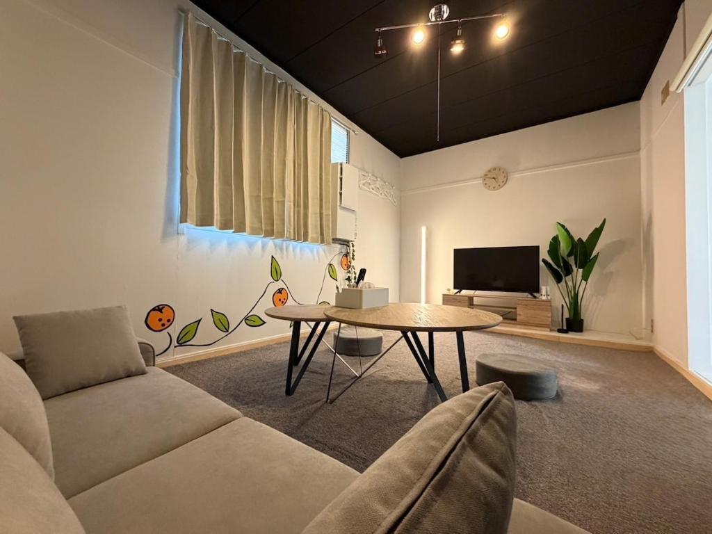 a living room with a couch and a table at mkh room TAKAMATSU in Takamatsu