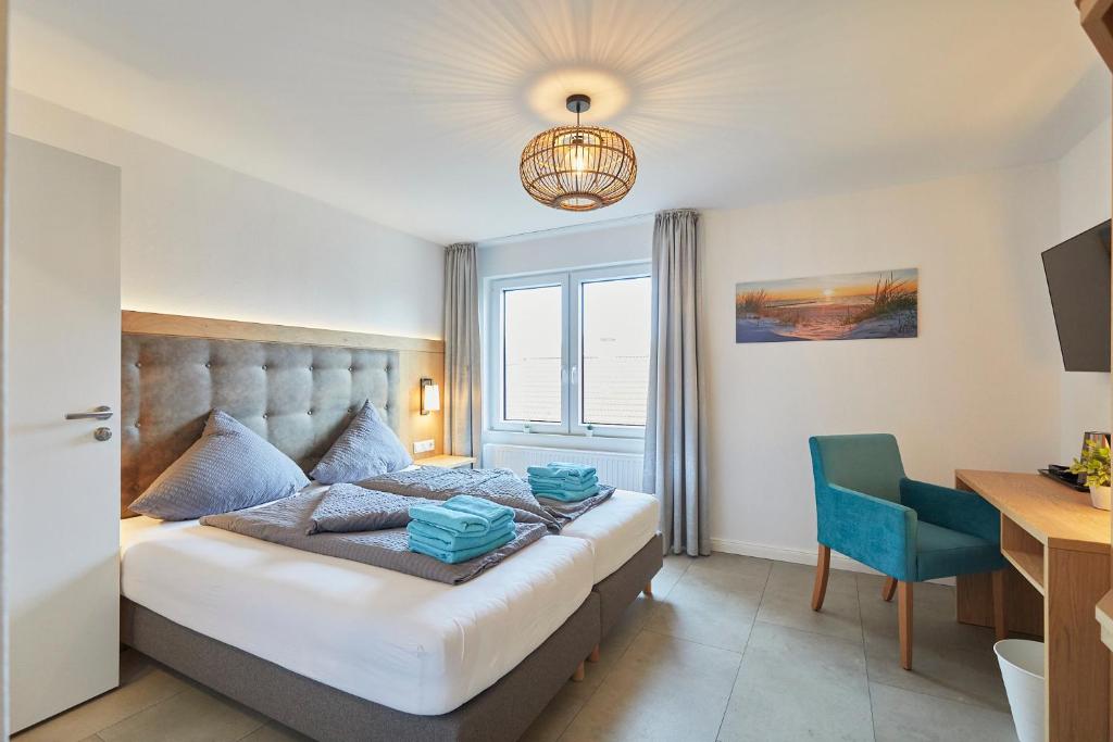 a bedroom with a bed and a desk and a chair at Haus Antina - App 2 in Borkum