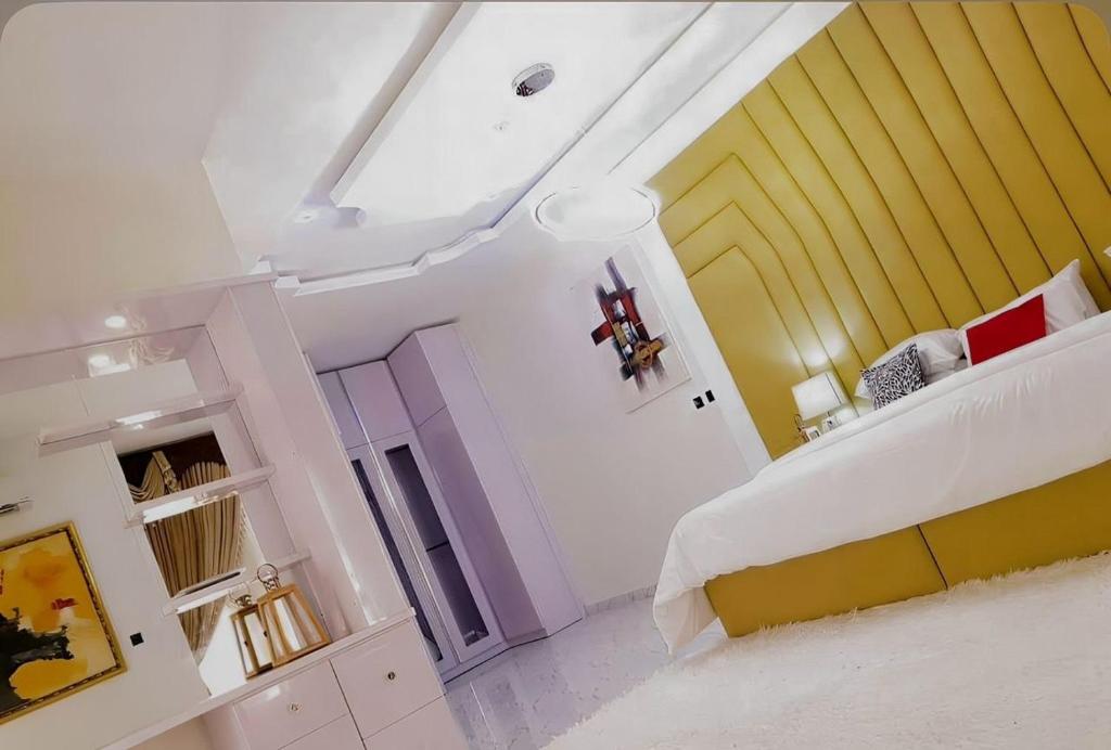 a bedroom with a white bed and a yellow wall at Msb LUXURY HOME in Lekki