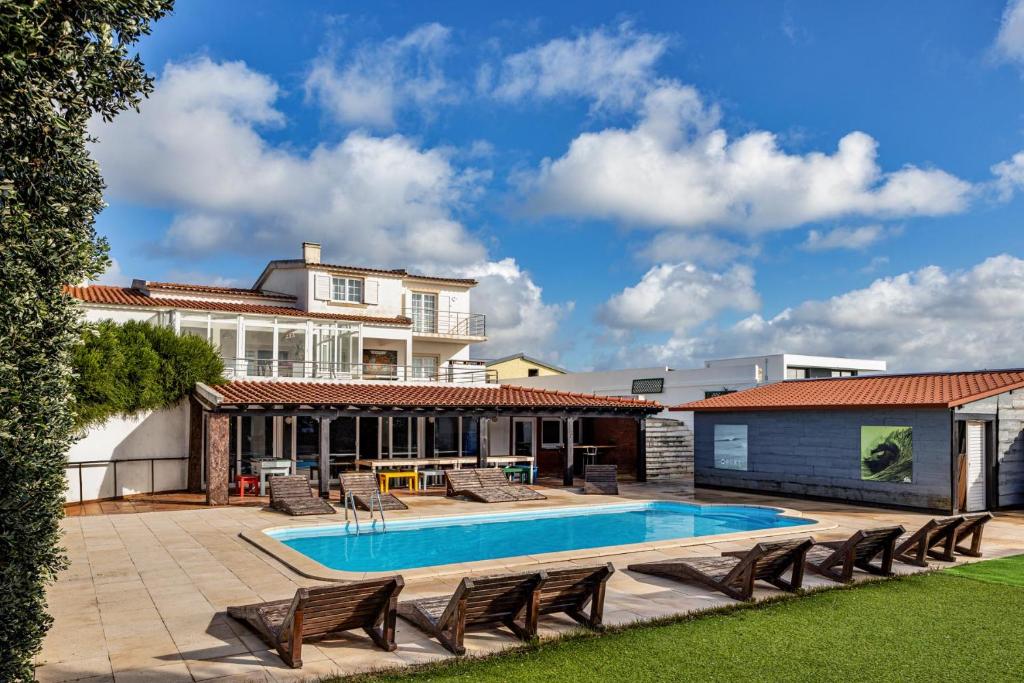 a house with a swimming pool in the yard at FreeSurfCamp in Peniche