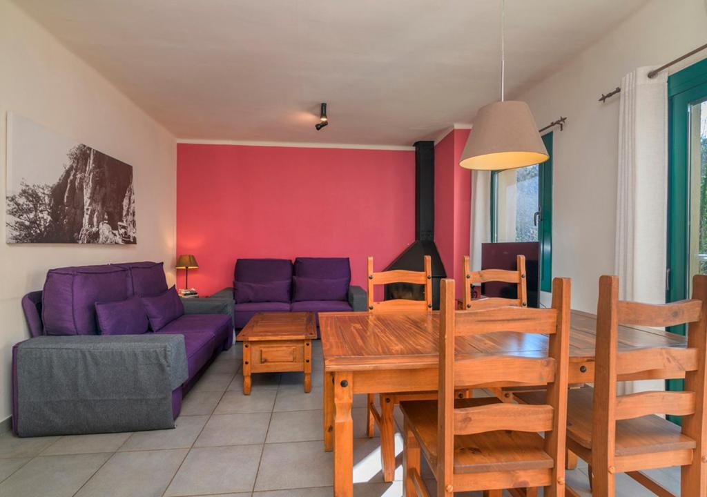 a living room with a purple couch and a table at Apartaments Rural Montseny in gualba de Dalt