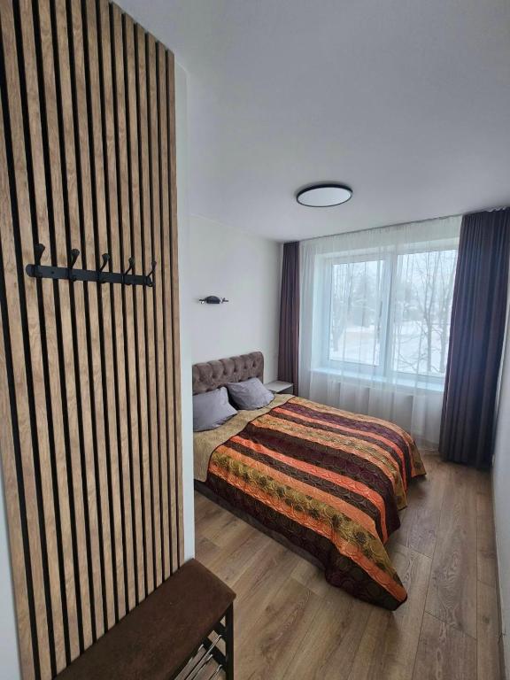 a bedroom with a bed and a large window at Muskatas in Rietavas