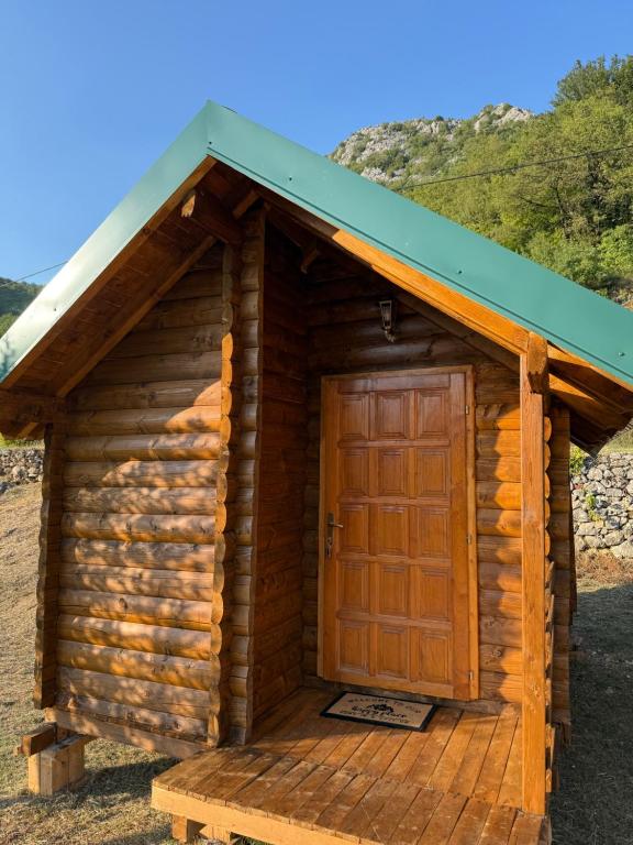 a small log cabin with a wooden door at ORAHOVSTICA TRAIL - Glamping in Dupilo