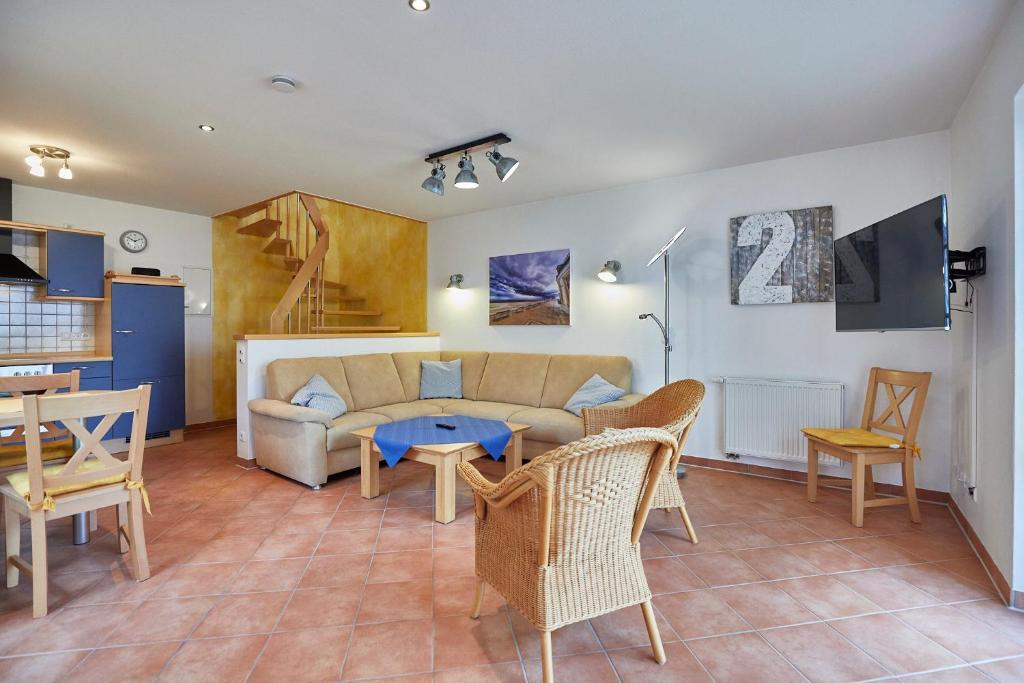 a living room with a couch and a table and chairs at Haus Meyer-Teerling - Ferienhaus in Borkum