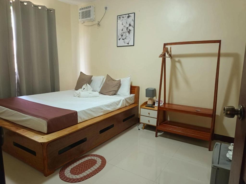 a bedroom with a bed with a mirror and a dresser at D' TRAVELLERS Inn PUERTO in Puerto Princesa City