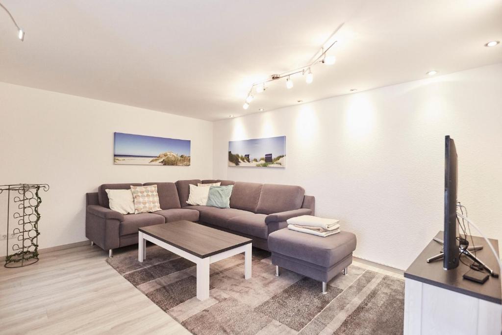 a living room with a couch and a tv at Ferienhaus Lina in Borkum