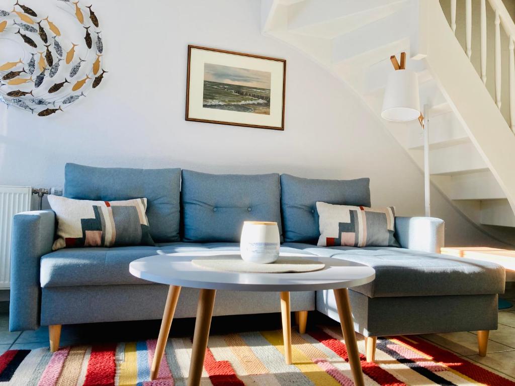 a living room with a blue couch and a table at Achtern Diek 12b - Wohnung 5 in Müggenburg