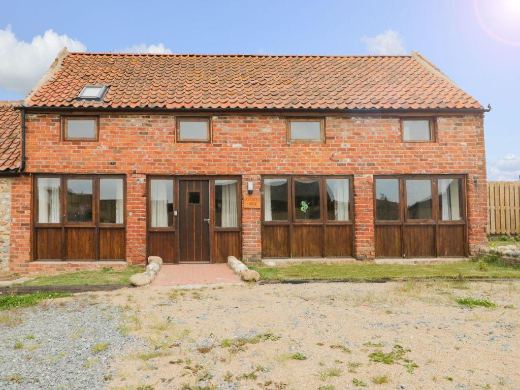 a brick house with a wooden door and windows at Lavender Lodge in Hull