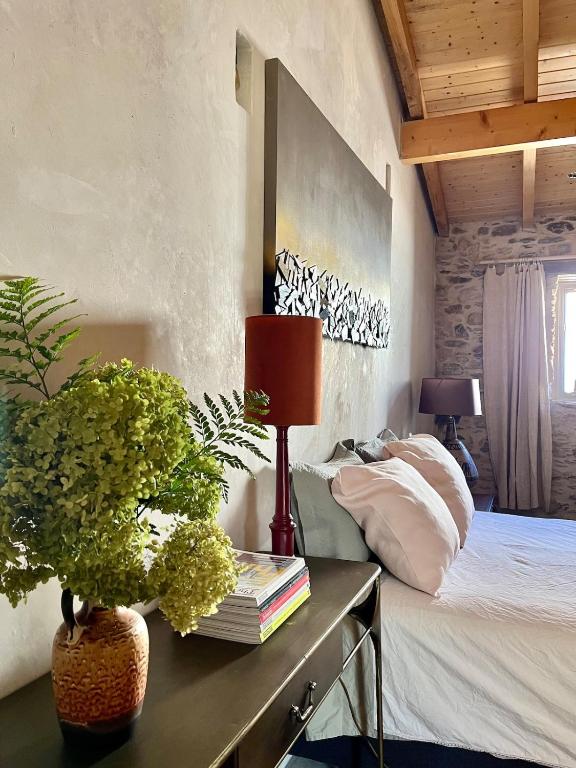 ein Schlafzimmer mit einem Bett und einem Tisch mit einer Lampe in der Unterkunft Casa 5A - Refúgio Intimo e privado com design e pátio acolhedor in Oliveira do Mondego