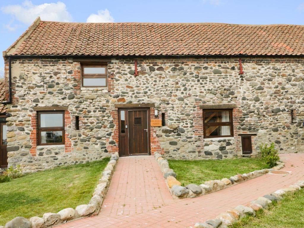 a stone house with a brick walkway in front of it at Mulberry Manor in Hull