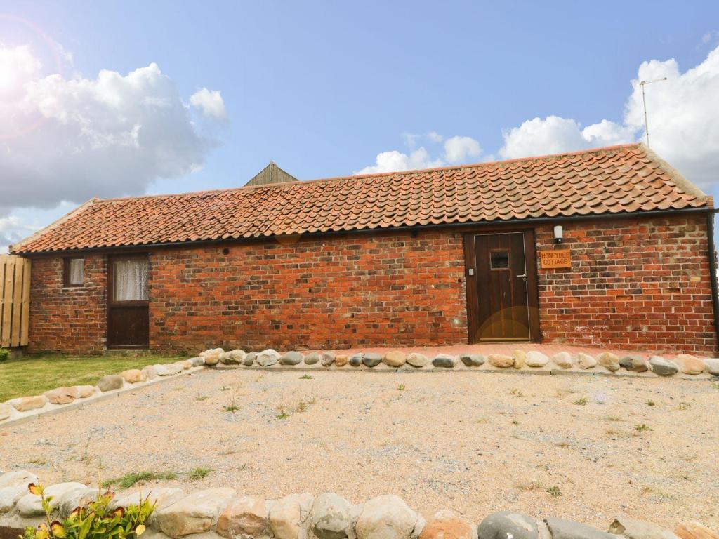 a brick house with a large yard in front of it at Honeybee Cottage in Hull
