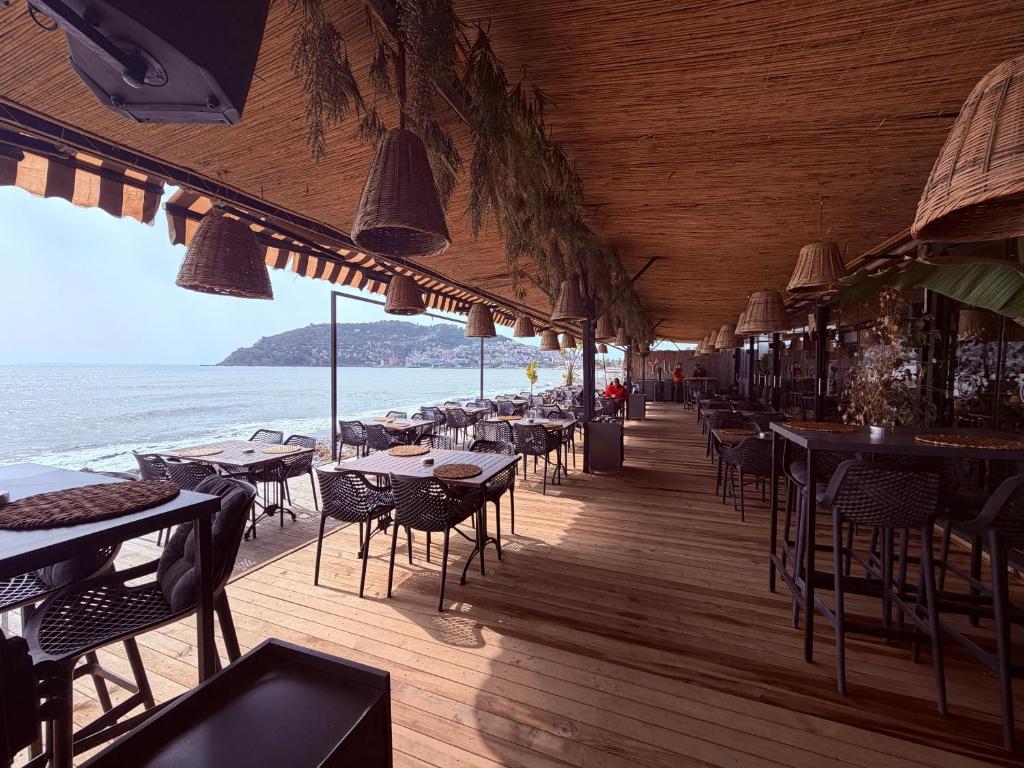 a restaurant with tables and chairs on the beach at Grand Alisa Hotel (Ex. Royalisa Hotel) in Alanya