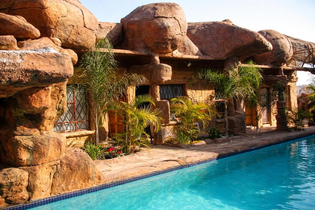 a resort with a pool and a rock wall at Ndou The Rocks Lodge in Hammanskraal Station